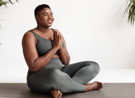 woman sitting cross legged eyes with prayer hands and eyes closed