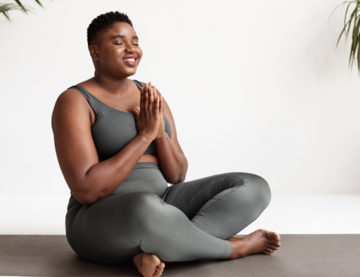 woman sitting cross legged eyes with prayer hands and eyes closed