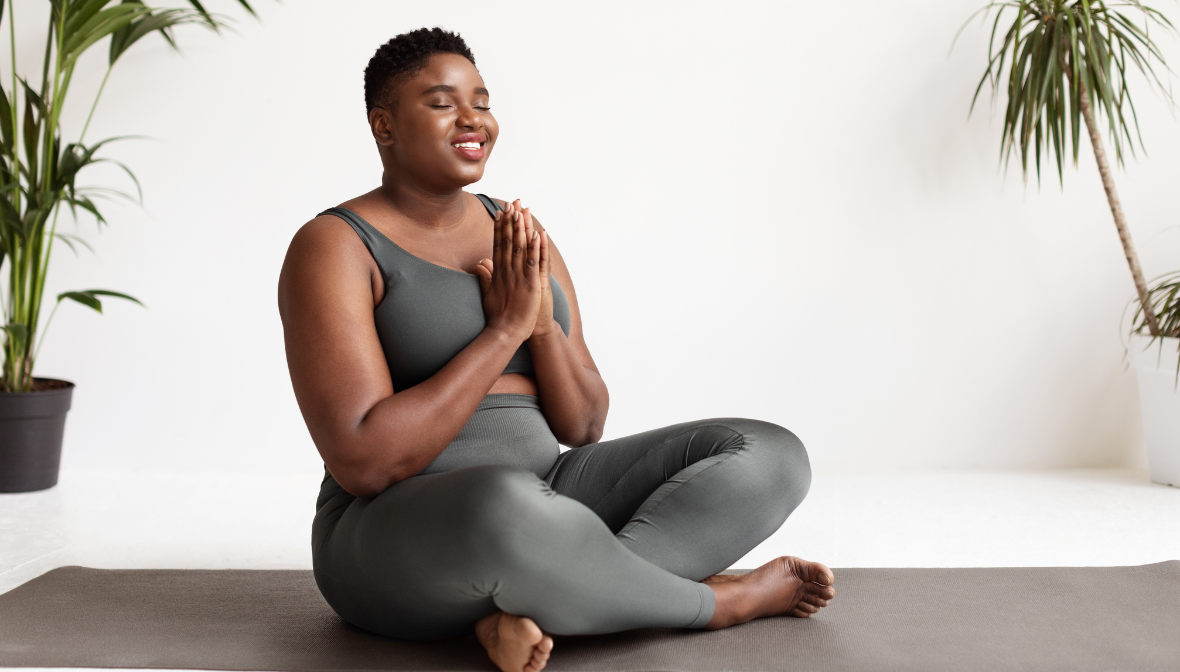 woman sitting cross legged eyes with prayer hands and eyes closed